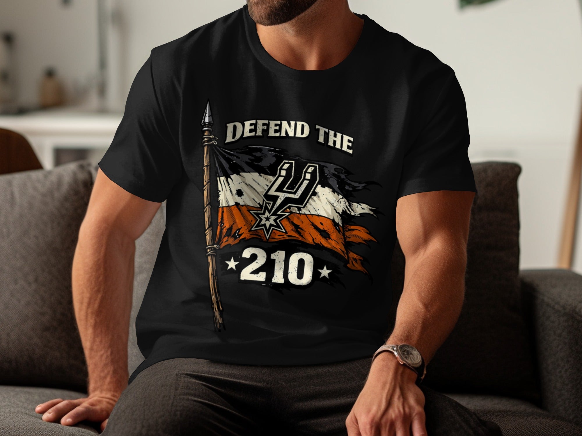 Black t-shirt with a tattered flag, "DEFEND THE 210" text, and Spurs logo.