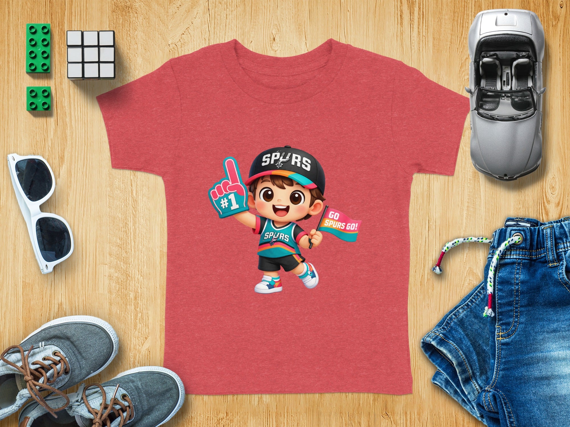 Red t-shirt with Spurs graphic of a cheering cartoon child holding a "#1" foam finger and flag.