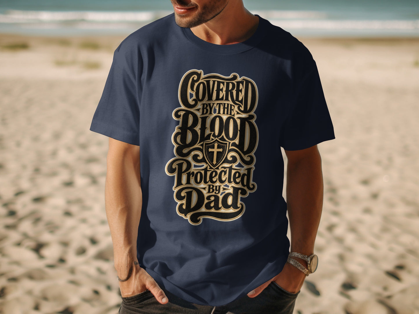 Navy t-shirt with "Covered By The Blood Protected By Dad" text and shield with cross.