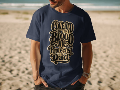 Navy t-shirt with "Covered By The Blood Protected By Dad" text and shield with cross.