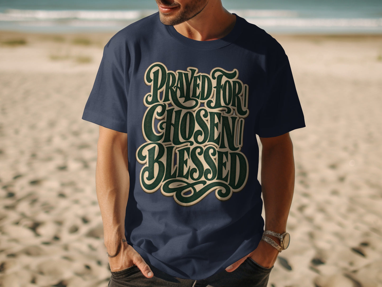 Navy t-shirt with "Prayed For Chosen Blessed" text design on a beach.