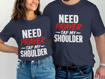 Two people wear navy t-shirts with "NEED PRAYER - TAP MY SHOULDER" text.
