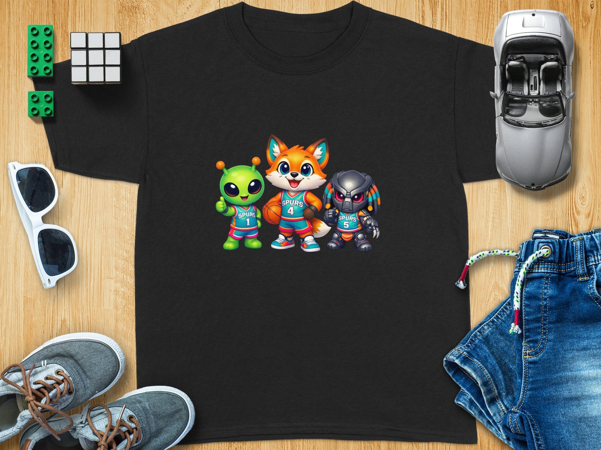 Black t-shirt with cartoon alien, fox, and predator characters wearing Spurs jerseys.