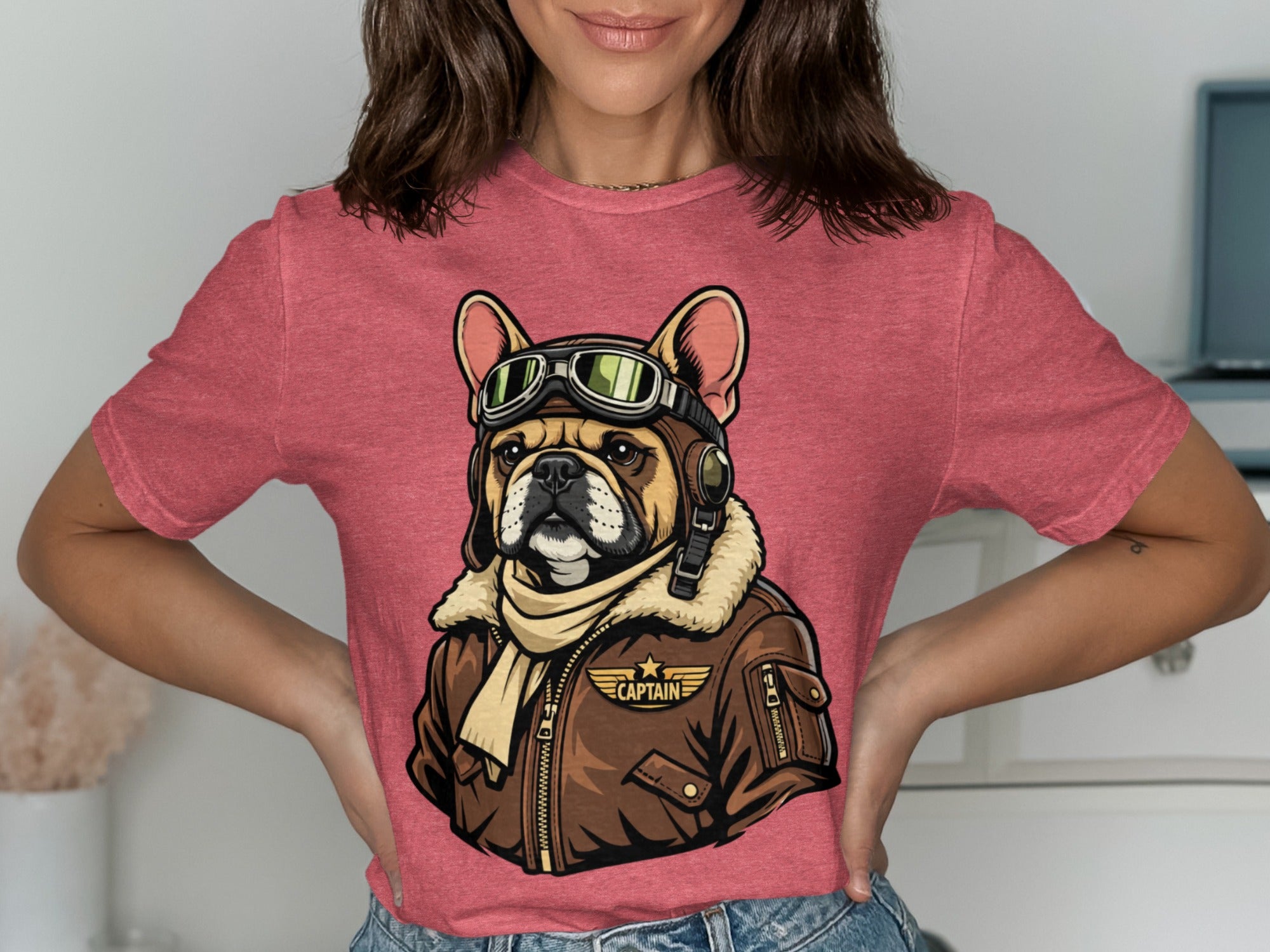 French bulldog wearing aviator goggles and jacket with "CAPTAIN" text.