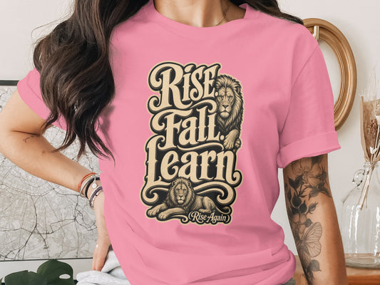 Pink t-shirt with "Rise Fall Learn Rise Again" text and lion graphics.