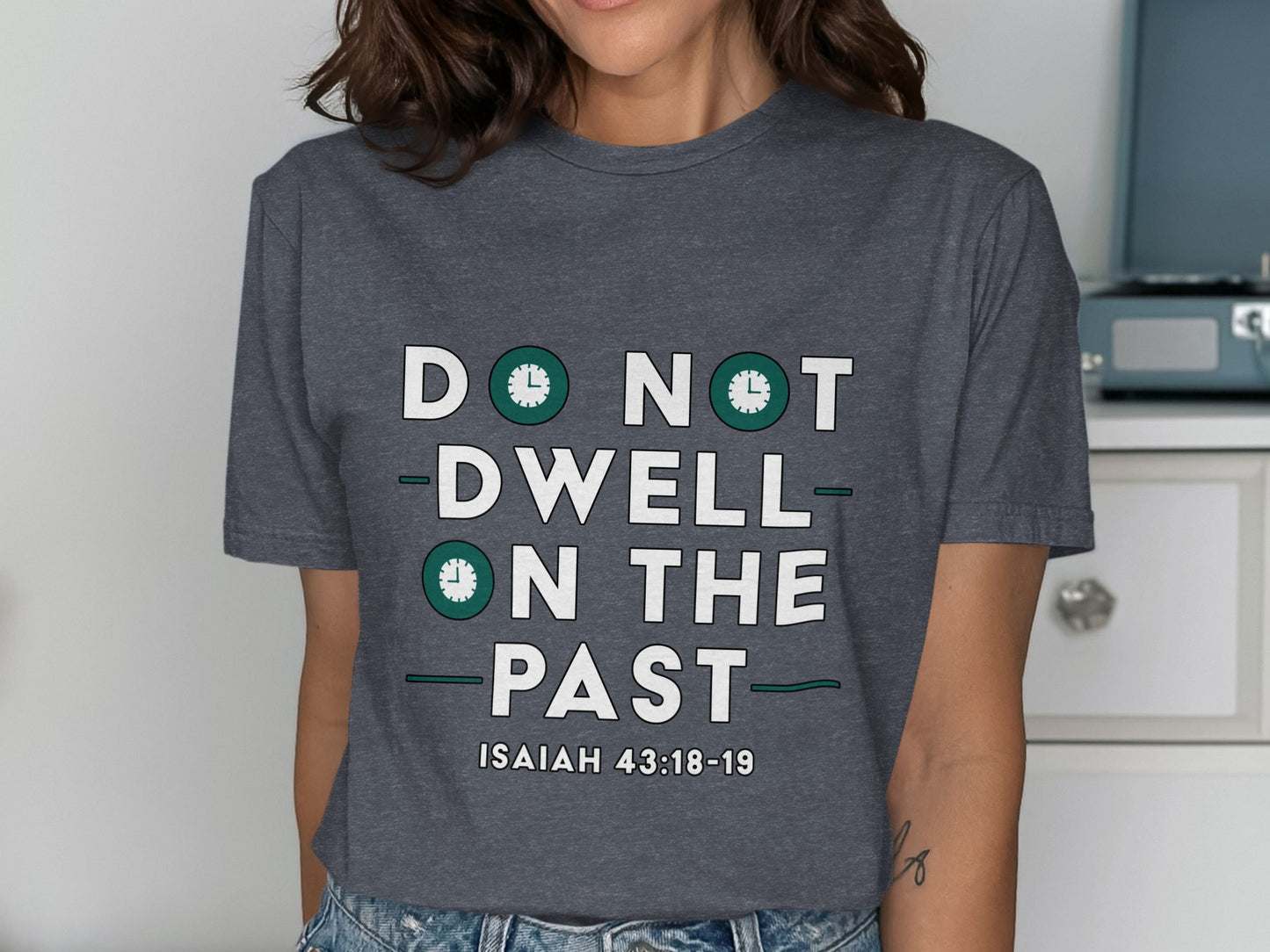 Dark gray t-shirt with "DO NOT DWELL ON THE PAST" and "ISAIAH 43:18-19" text.