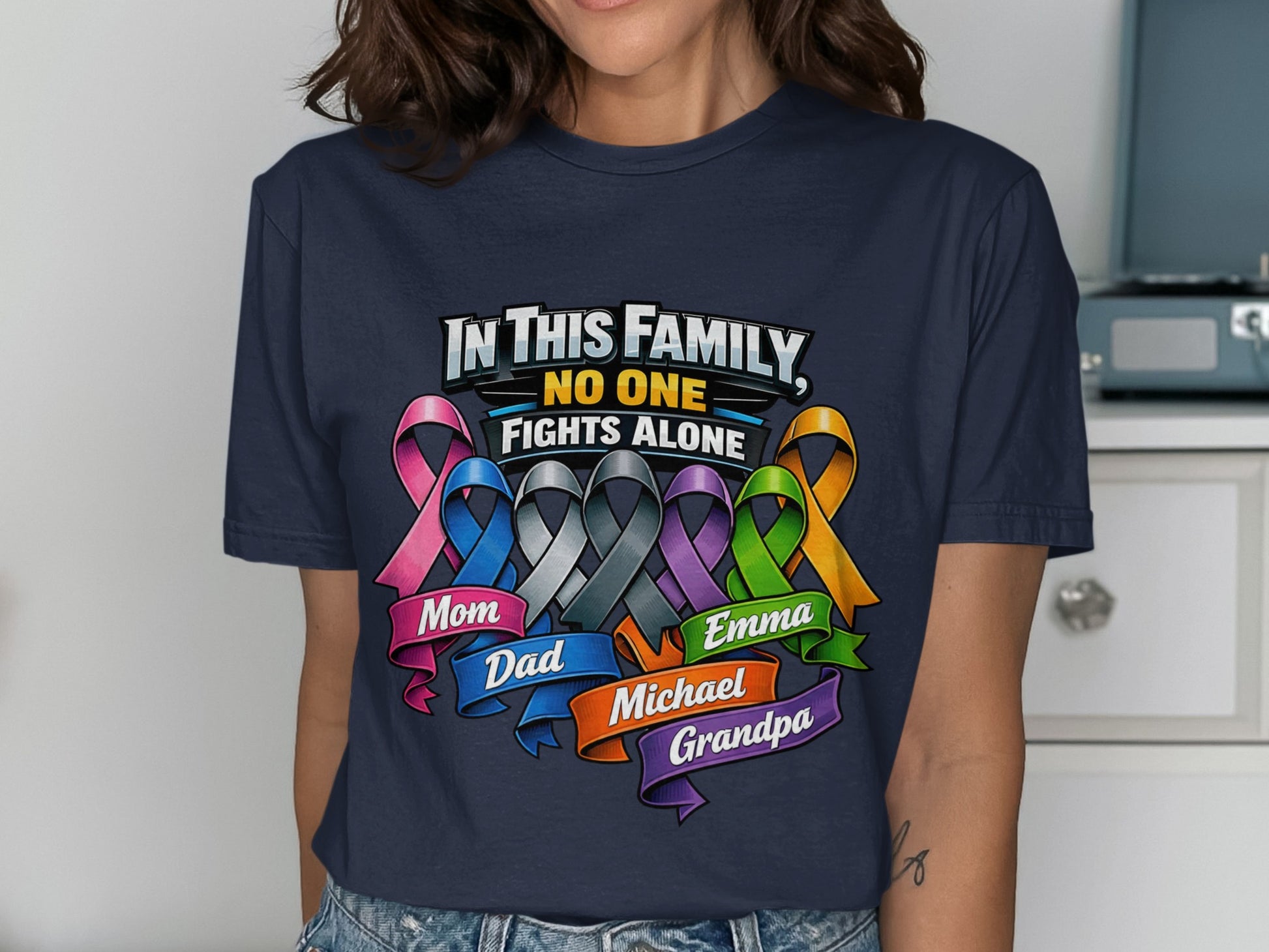 Navy shirt with "In This Family, No One Fights Alone" and named ribbons.