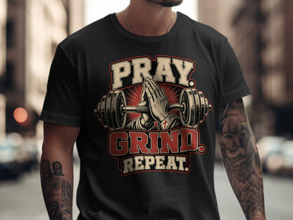 Black t-shirt with Pray. Grind. Repeat. text and praying hands between dumbbells.
