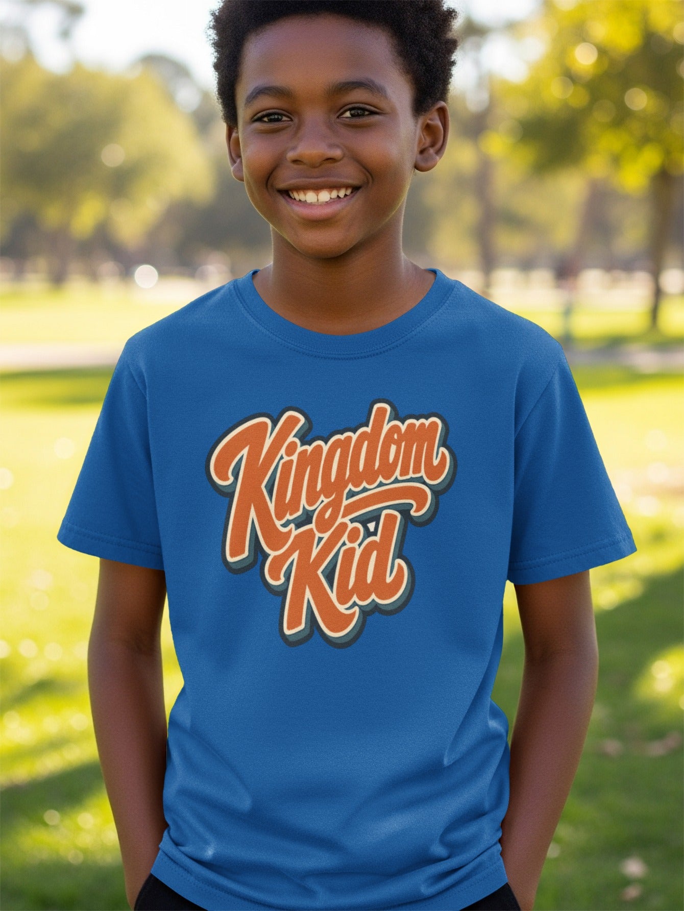 Boy in blue t-shirt with orange and cream "Kingdom Kid" graphic.