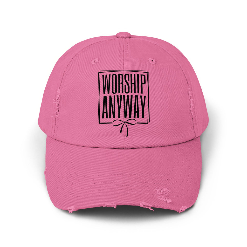 Pink distressed baseball cap with black text "WORSHIP ANYWAY" inside a box.