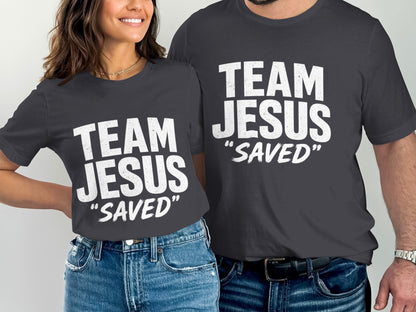 Two people in dark grey t-shirts with white text "TEAM JESUS "SAVED""