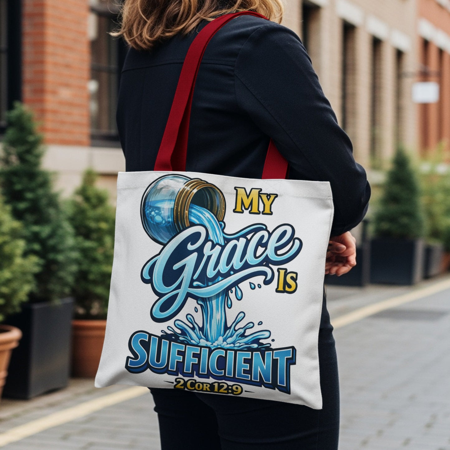 White tote bag with "My Grace Is Sufficient" in blue and yellow text.