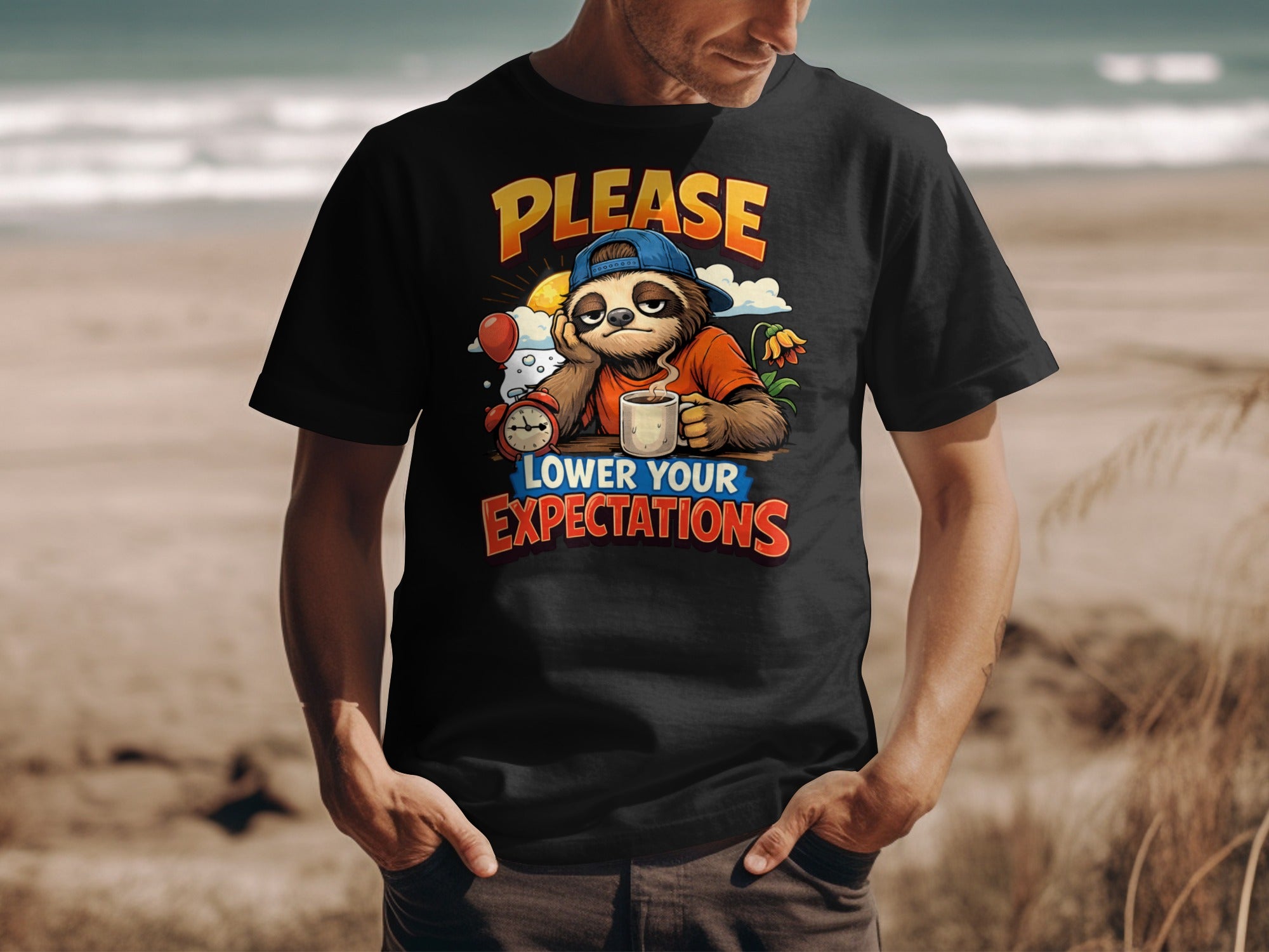 T-shirt graphic of a sloth in a blue cap with coffee, alarm clock, and text "PLEASE LOWER YOUR EXPECTATIONS".