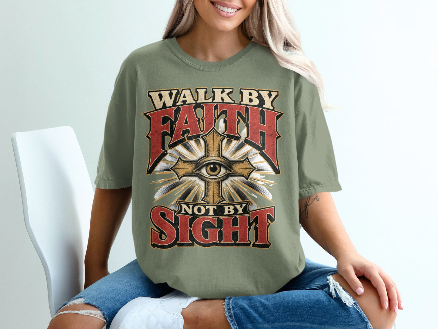 Olive green t-shirt with textured text reading "WALK BY FAITH NOT BY SIGHT" and an eye.