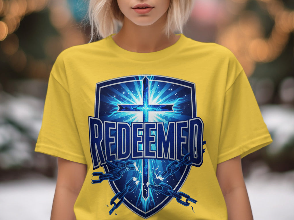 Yellow t-shirt with a blue shield graphic featuring a glowing cross and broken chains.