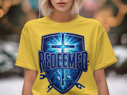 Yellow t-shirt with a blue shield graphic featuring a glowing cross and broken chains.