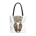 White tote bag with "Walking by Faith, not Sight" and boot sole prints.