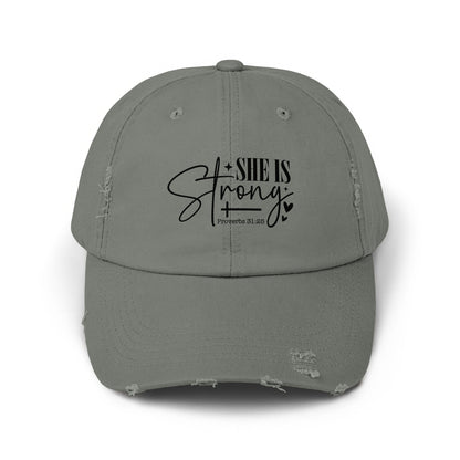 Distressed grey baseball cap with black text "SHE IS Strong" and "Proverbs 31:25".