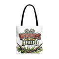 White tote bag with "By His Wounds We Are Healed Isaiah 53:5" text and olive branches.