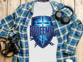 White t-shirt with blue shield graphic saying "REDEEMED" and broken chains.