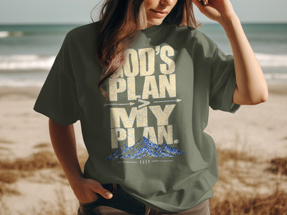 Green t-shirt with "God's Plan, My Plan" and mountain graphic.