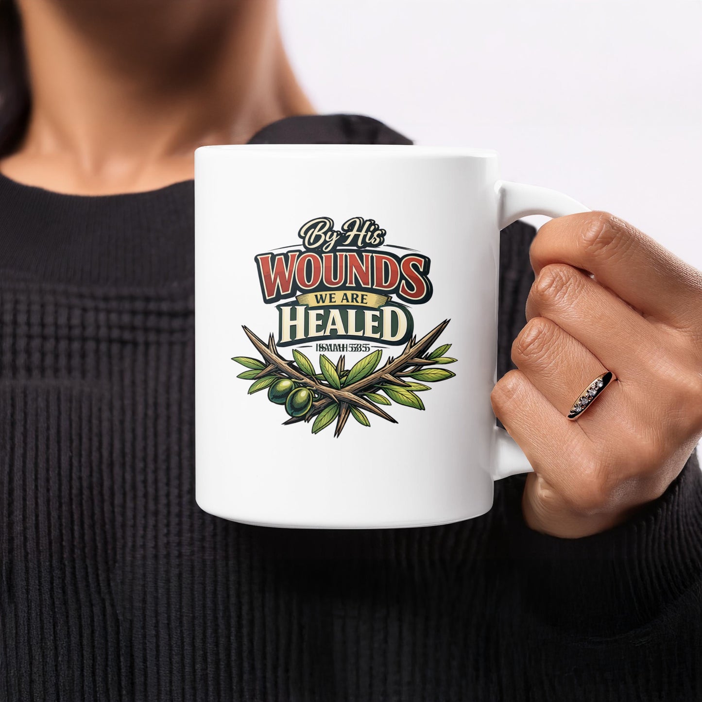 White mug with text "By His Wounds We Are Healed Isaiah 53:5" and olive branch.