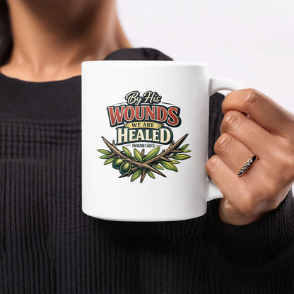 White mug with text "By His Wounds We Are Healed Isaiah 53:5" and olive branch.