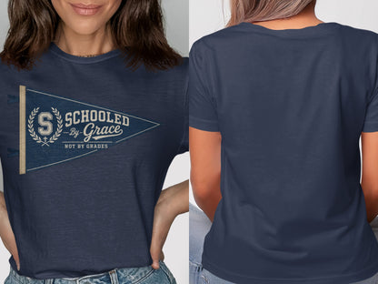Navy t-shirt with a pennant graphic reading "SCHOOLED -By- Grace NOT BY GRADES".