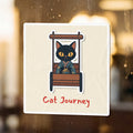 Black cat in a kimono sitting in a wooden cart with "Cat Journey" text.