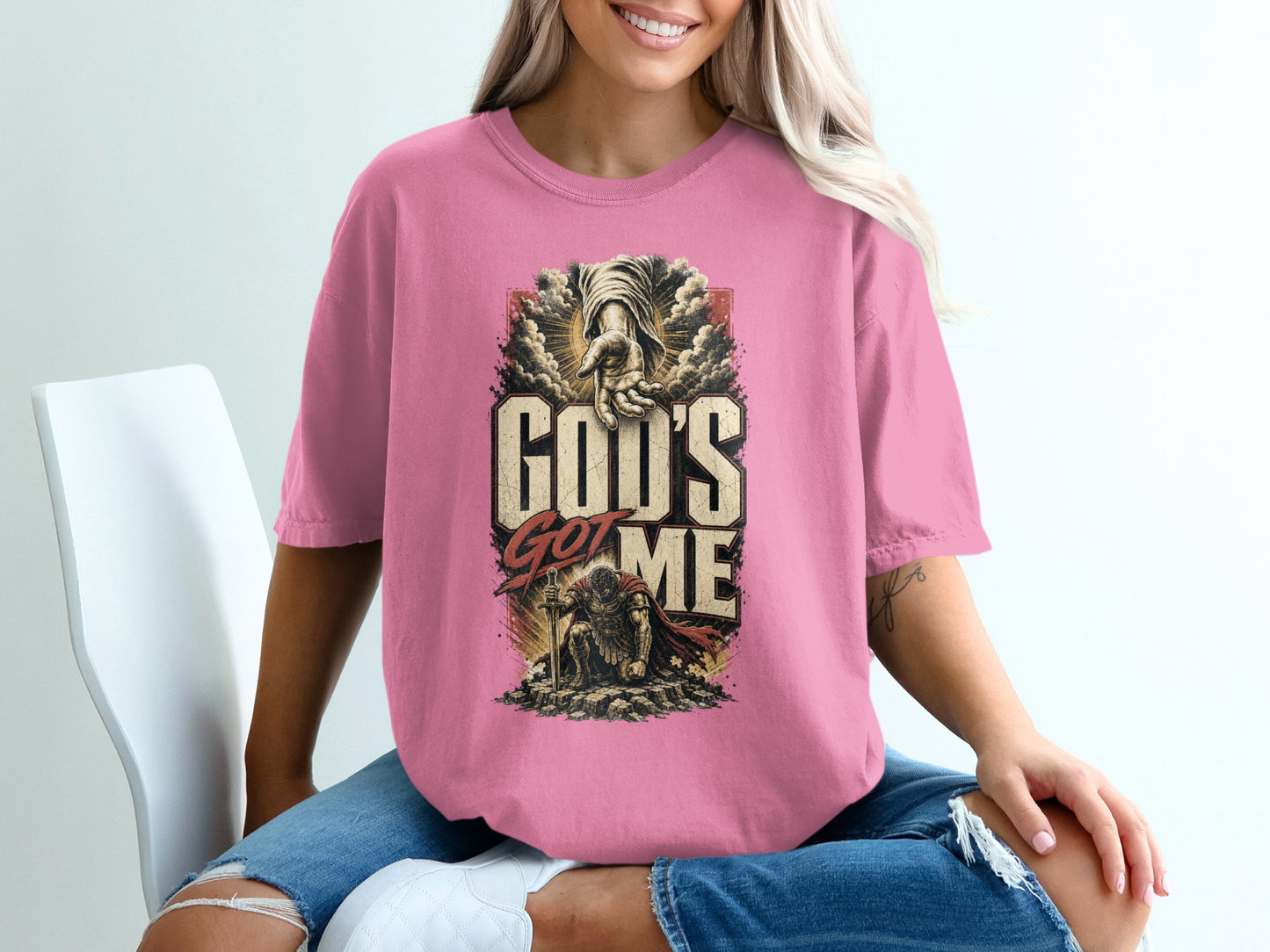 Pink t-shirt with graphic "God's Got Me" and kneeling warrior art.