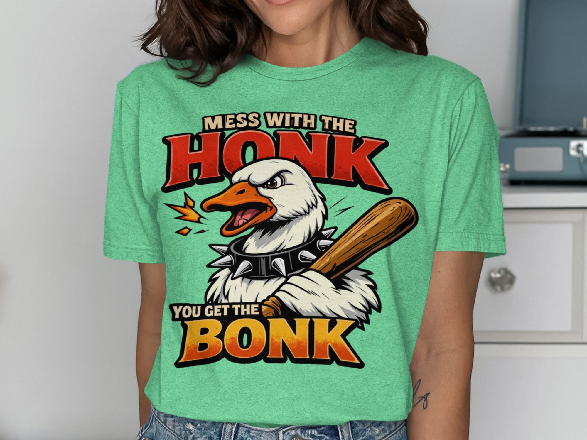 Green graphic tee with text "MESS WITH THE HONK YOU GET THE BONK" and a cartoon goose.