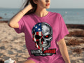 Pink t-shirt with a graphic of a skull, half American flag, half metallic with a red eye