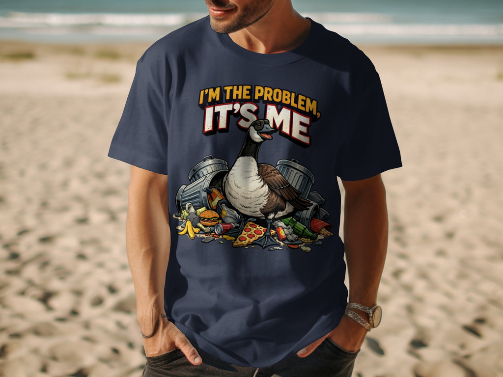 Dark blue t-shirt with a graphic of a goose next to trash cans and food, reading "I'M THE PROBLEM, IT'S ME".