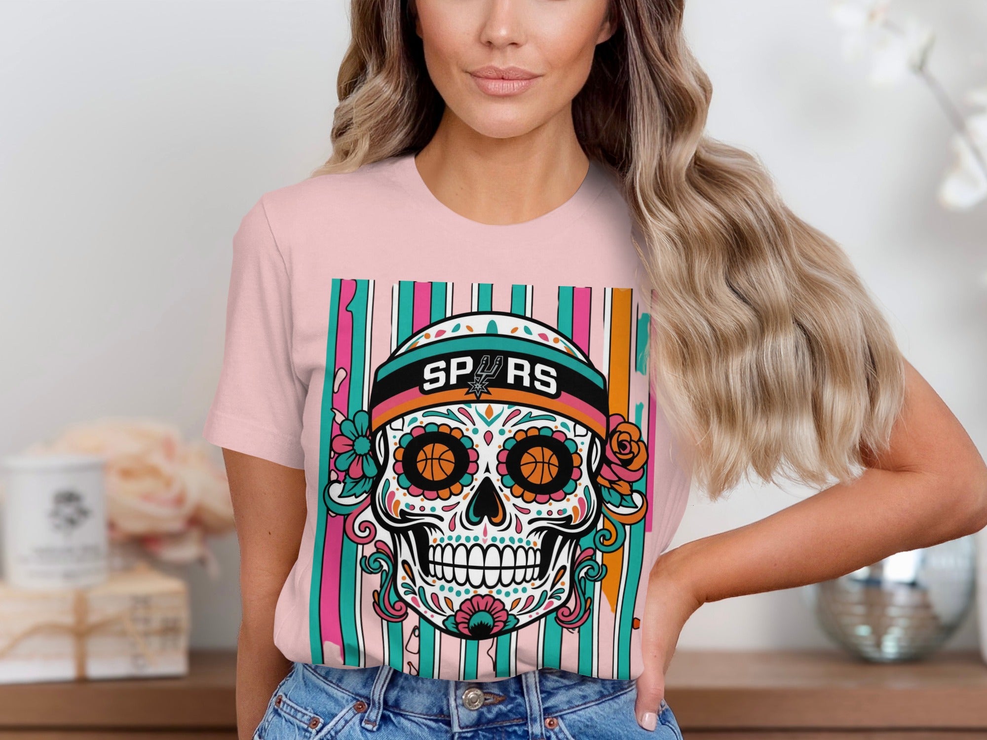 Pink t-shirt with colorful sugar skull graphic, Spurs logo, and striped background.