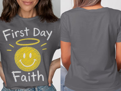 Grey t-shirt with yellow smiley face, halo, and text "First Day Faith".
