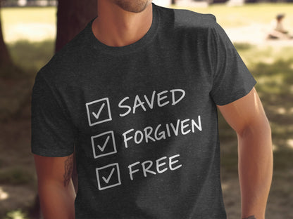 Dark t-shirt with white text: Saved, Forgiven, Free, all with checkmarks.