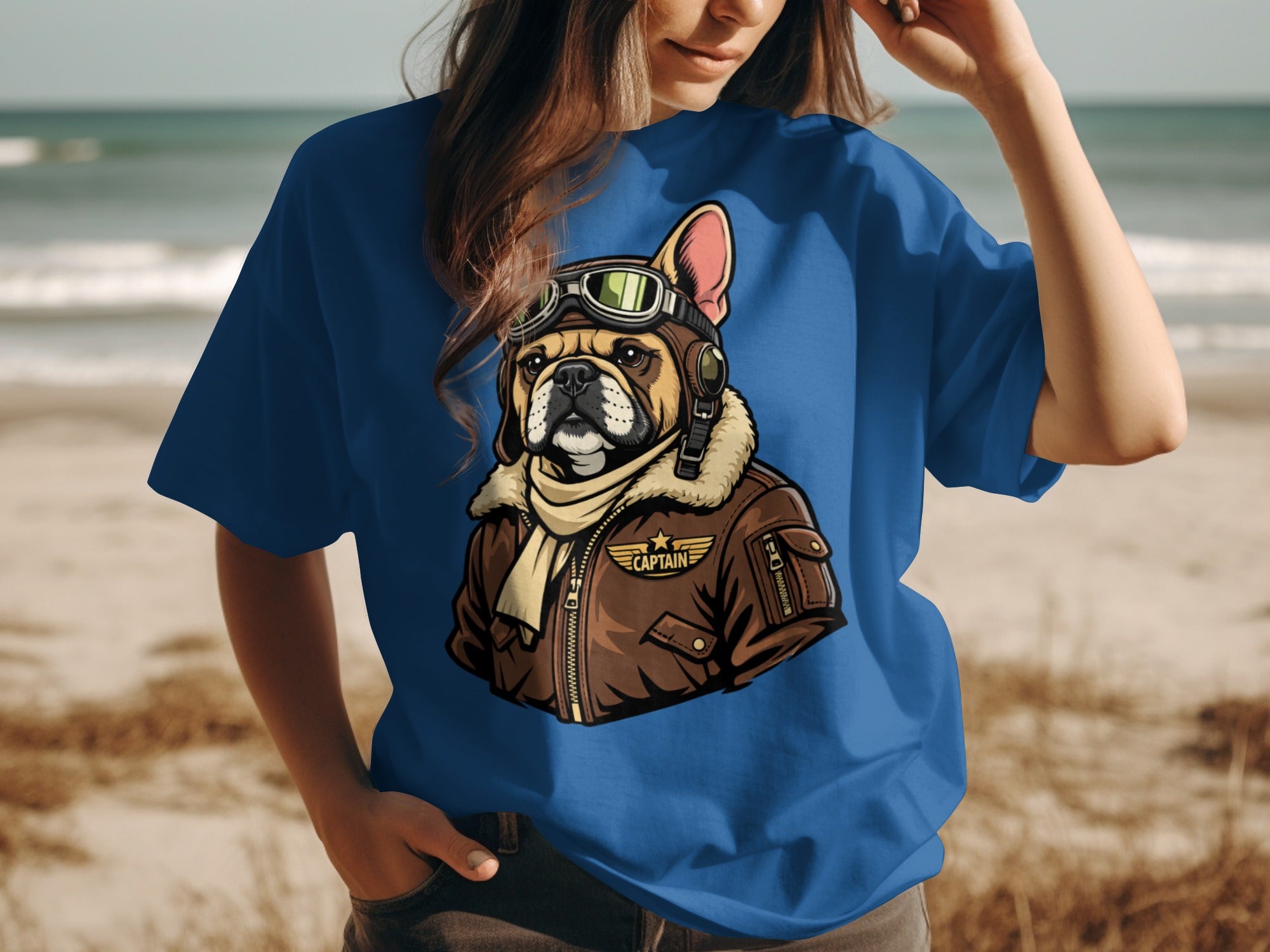 French bulldog wearing aviator goggles and jacket with "Captain" text.
