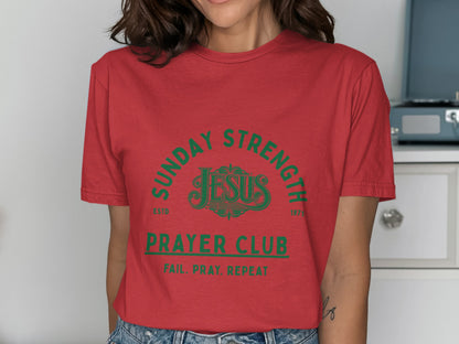 Red t-shirt with green text "Sunday Strength Jesus Prayer Club Fail. Pray. Repeat."