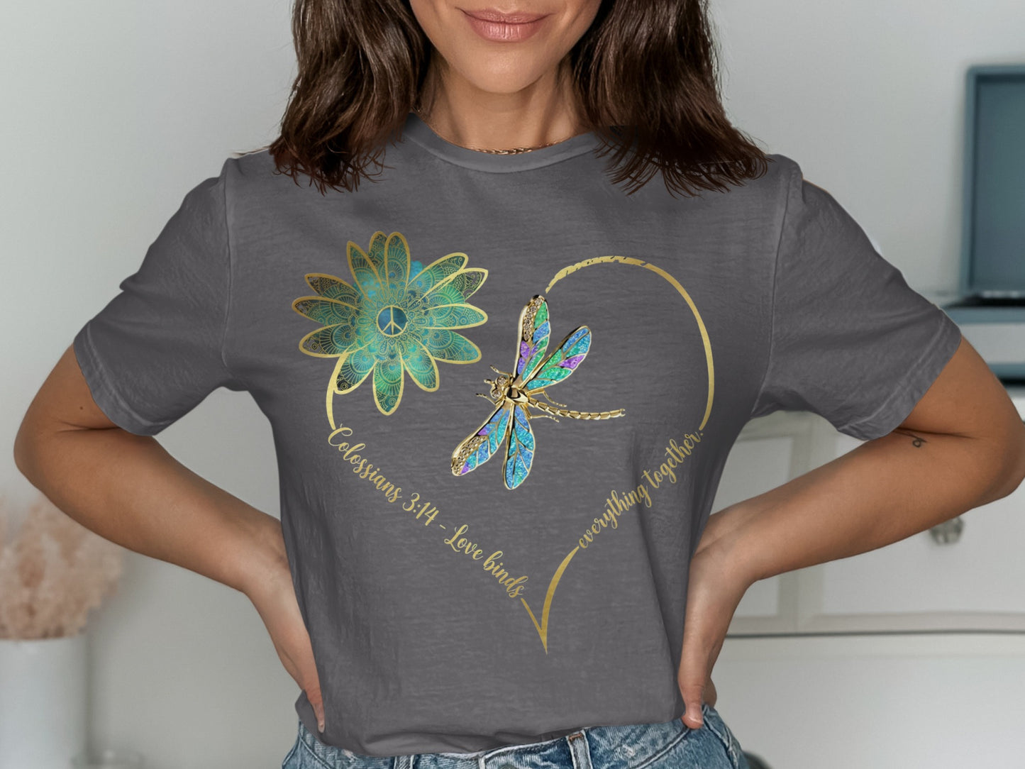 Grey t-shirt with a heart design, dragonfly, flower, and text "Colossians 3:14 - Love binds everything together."