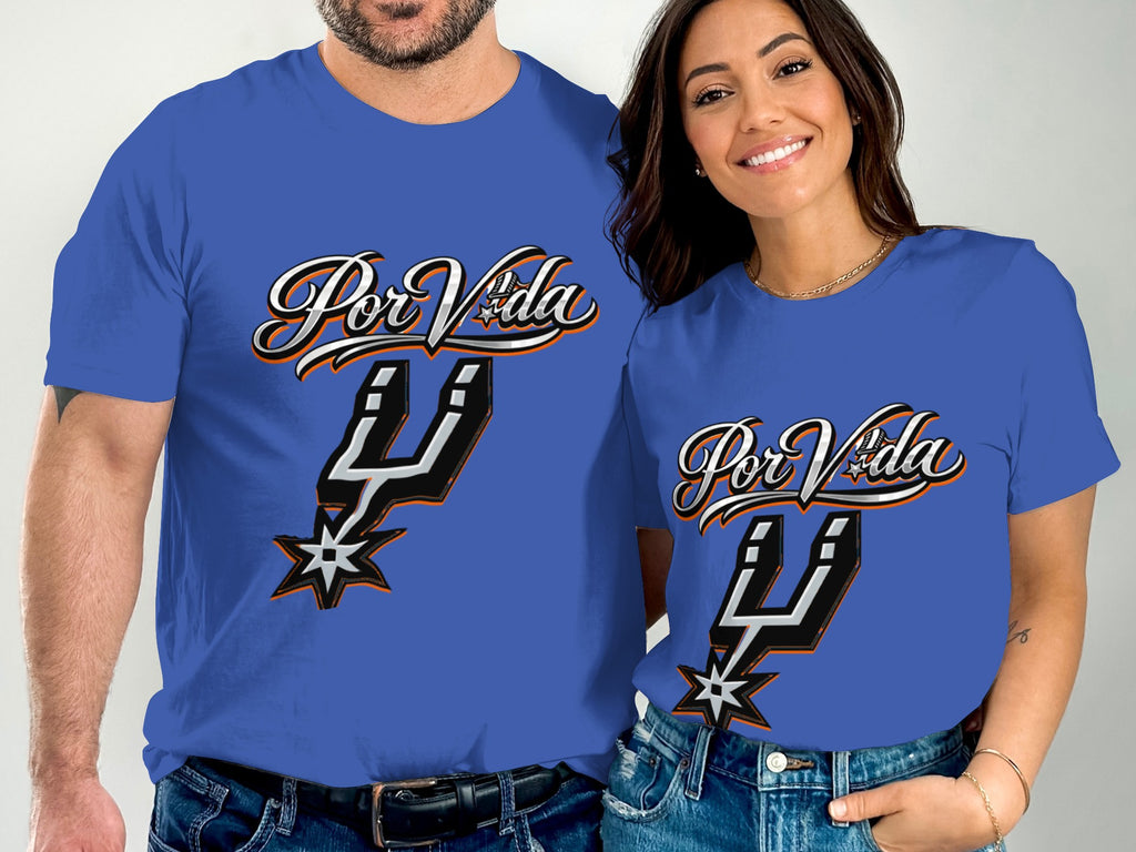 A man and woman wear matching blue t-shirts with "Por Vida" and a Spur logo.