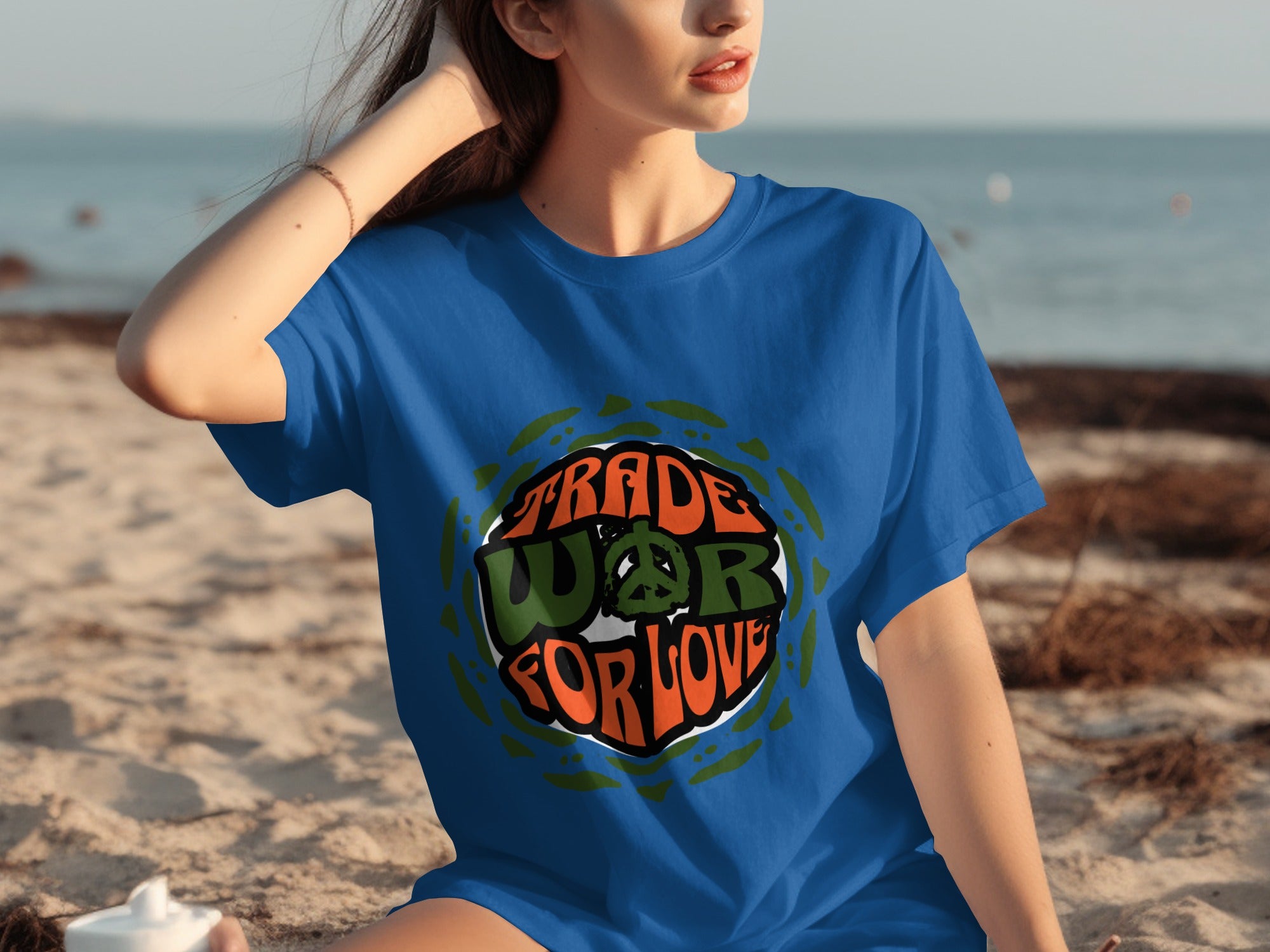 Blue t-shirt with "TRADE WAR FOR LOVE" and peace sign graphic on beach background