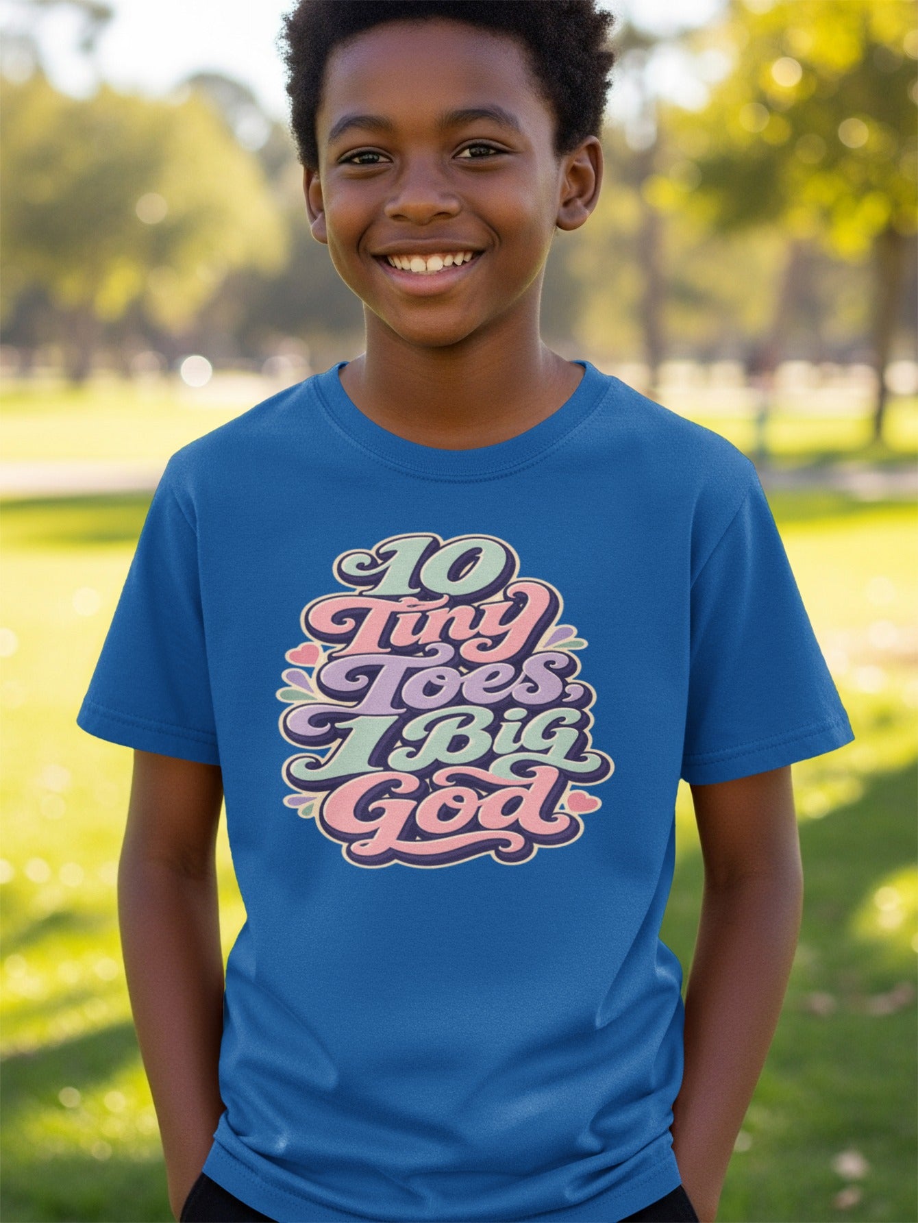 Boy in blue t-shirt with "10 Tiny Toes, Big God" text design.