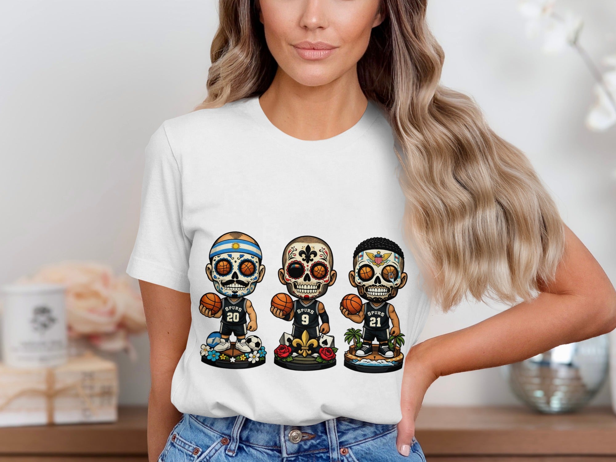 White t-shirt with three sugar skull basketball players, "Spurs" logos, and numbers 20, 9, and 21.