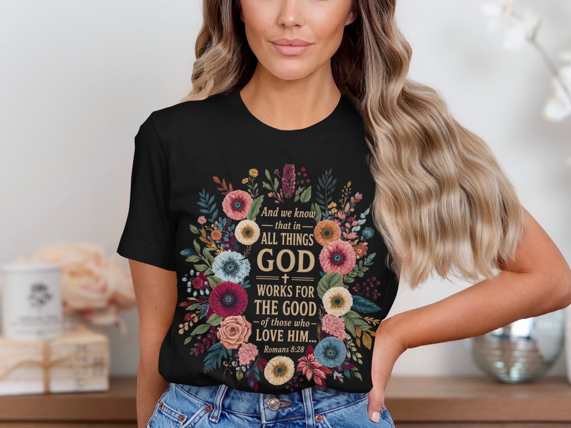 Black t-shirt with floral wreath and text "God works for the good... Romans 8:28".
