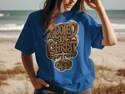 Blue t-shirt with "ROOTED IN CHRIST" and "Col. 2:7" text design over a tree root graphic.