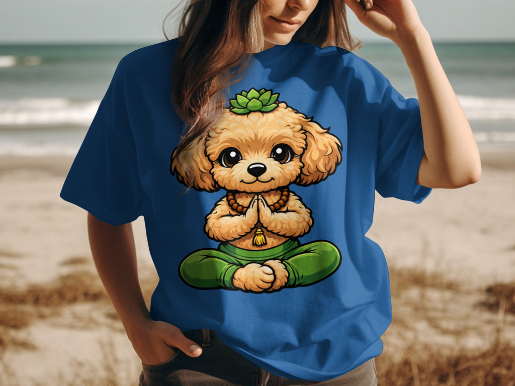 A cartoon dog sits in a meditation pose on a blue t-shirt worn by a person at the beach.