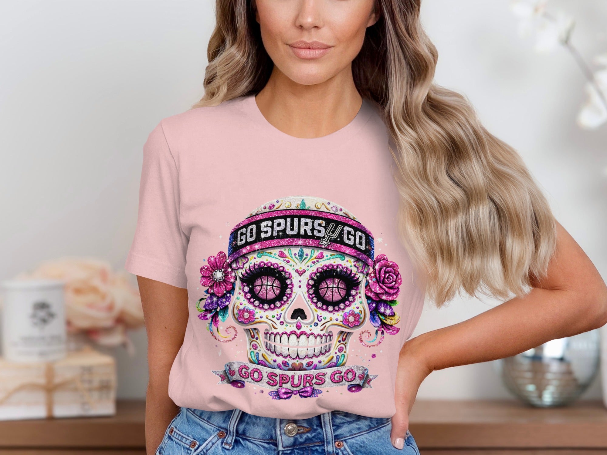 Pink t-shirt with a sugar skull graphic featuring basketball eyes and "GO SPURS GO" text.