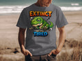 Gray t-shirt with a sleeping cartoon dinosaur and text "Extinct but still tired."