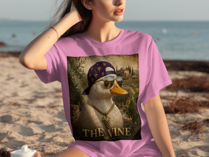 Pink t-shirt with a print of a duck wearing sunglasses, a gold chain, and a grape-patterned hat.