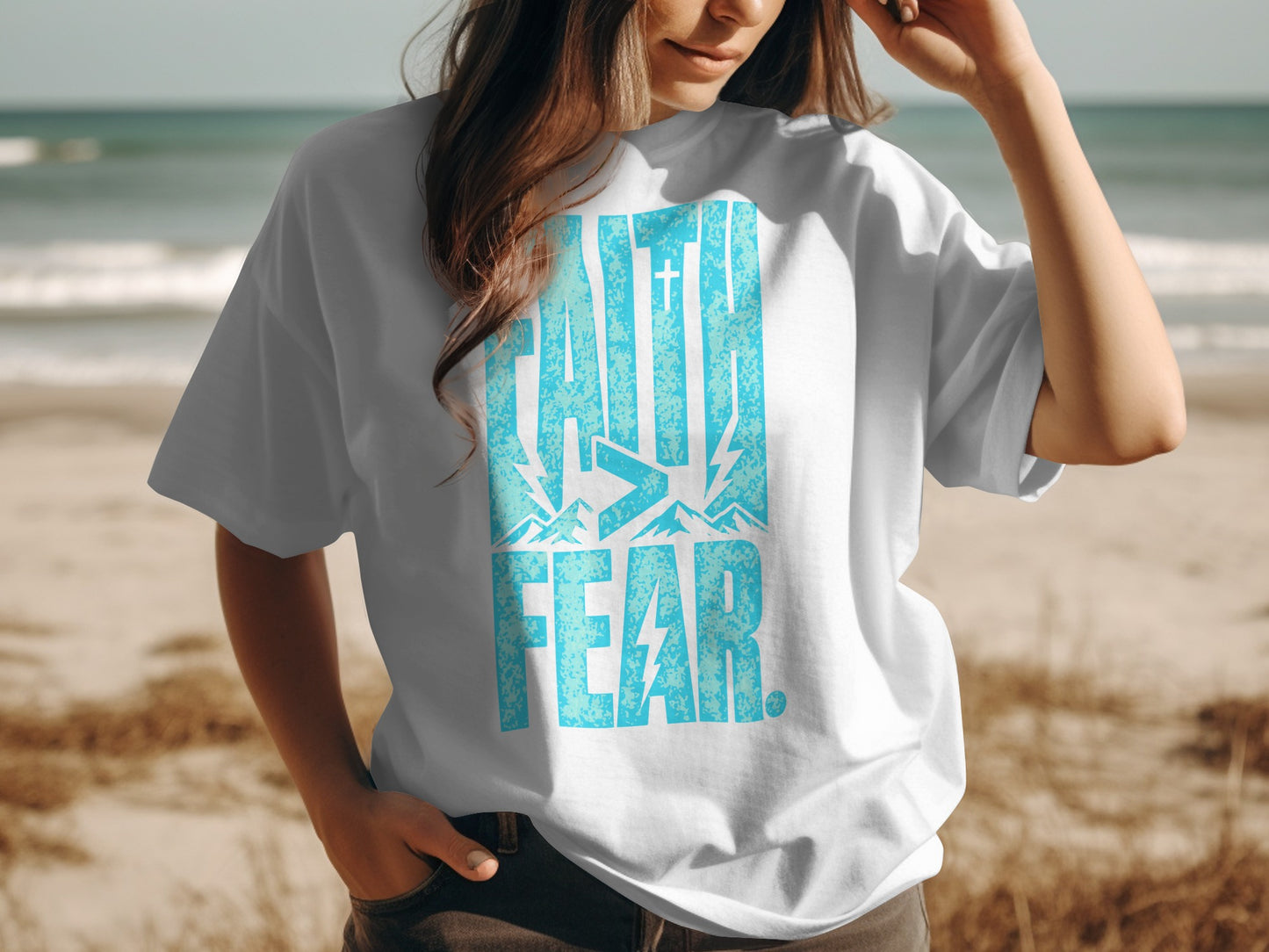 White t-shirt with blue distressed "FAITH > FEAR" graphic and mountain/cross design.